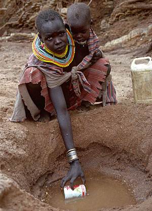 Kenyan Woman Scoops Water by Christopher Redner